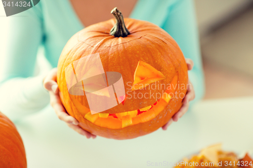 Image of close up of woman with pumpkins at home