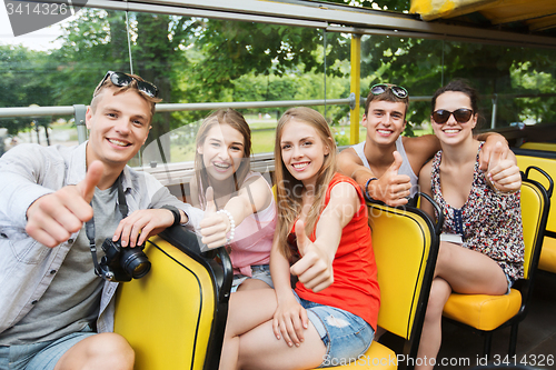 Image of friends traveling by tour bus showing thumbs up