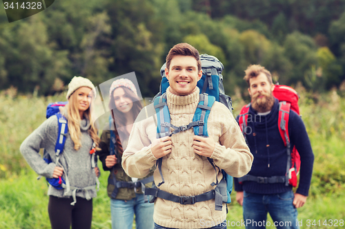 Image of group of smiling friends with backpacks hiking