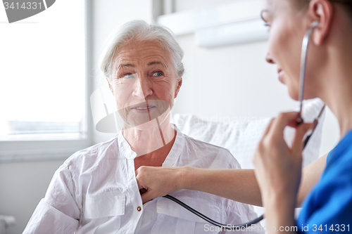 Image of nurse with stethoscope and senior woman at clinic