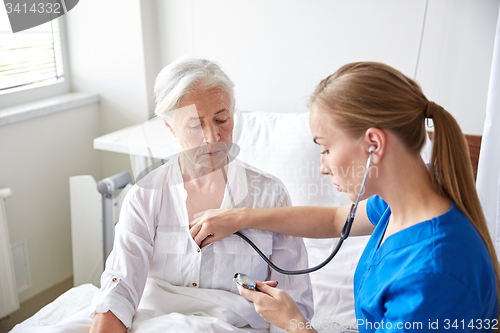 Image of nurse with stethoscope and senior woman at clinic