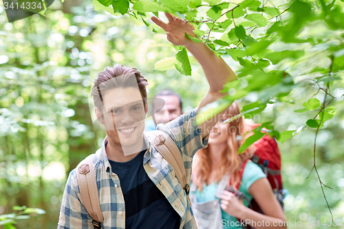 Image of group of smiling friends with backpacks hiking