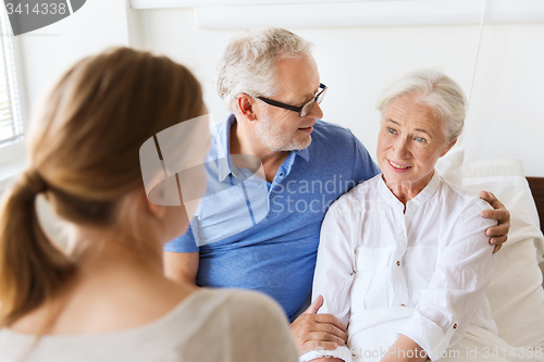 Image of happy family visiting senior woman at hospital