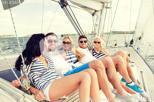 Image of smiling friends sitting on yacht deck