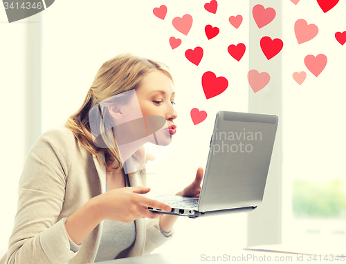 Image of woman sending kisses with laptop computer