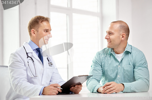 Image of male doctor and patient with clipboard at hospital