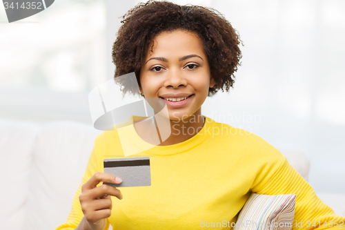 Image of happy african woman with credit or debit card