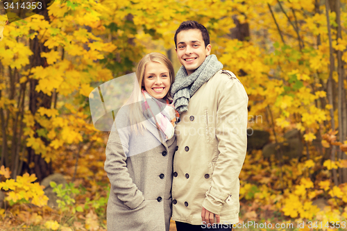 Image of smiling couple hugging in autumn park