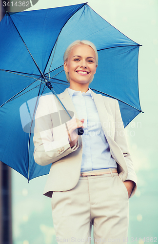 Image of young smiling businesswoman with umbrella outdoors