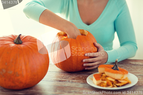 Image of close up of woman with pumpkins at home