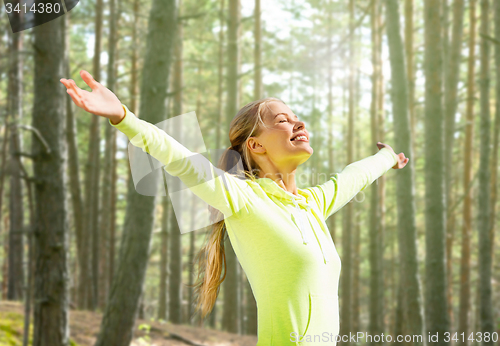 Image of happy woman in sport clothes raising hands