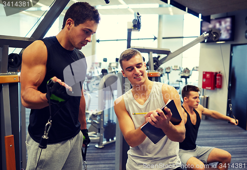 Image of men exercising on gym machine