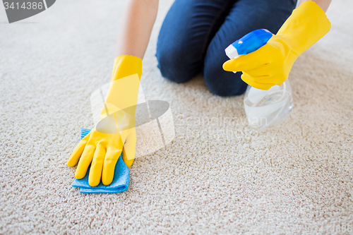 Image of close up of woman with cloth cleaning carpet