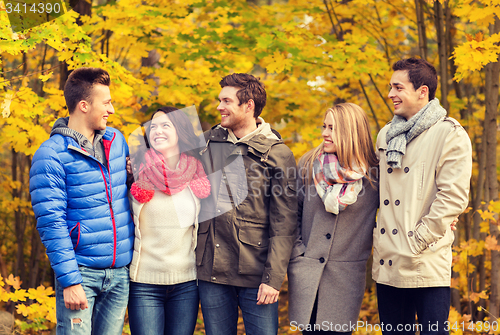 Image of group of smiling men and women in autumn park