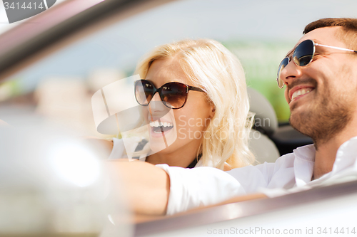 Image of happy man and woman driving in cabriolet car