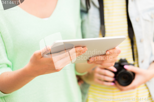 Image of close up of women with tablet pc and camera