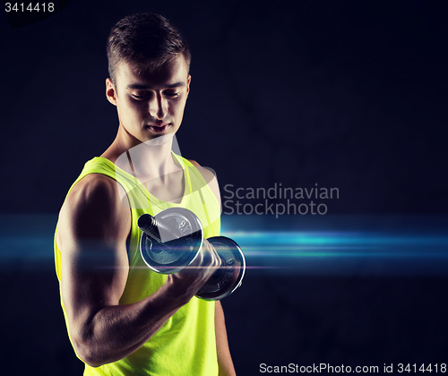 Image of young man with dumbbell flexing biceps