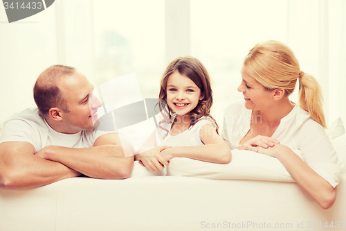 Image of smiling parents and little girl at home