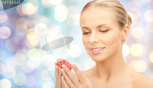 Image of beautiful woman with seashell over blue lights