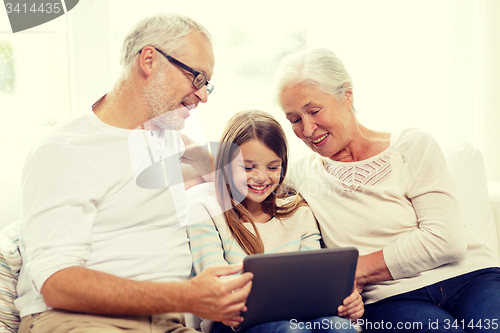 Image of smiling family with tablet pc at home