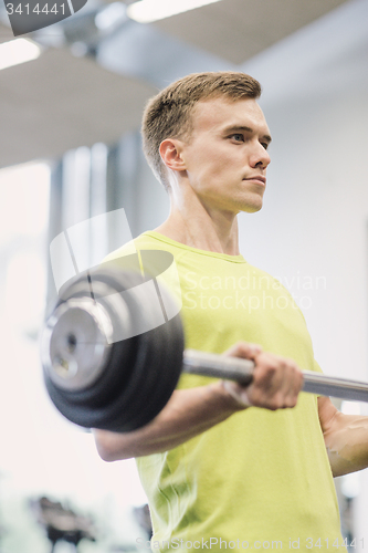 Image of man doing exercise with barbell in gym