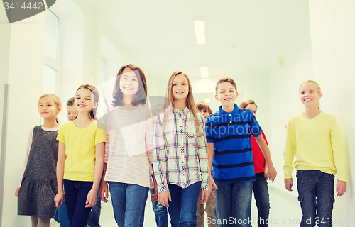 Image of group of smiling school kids walking in corridor