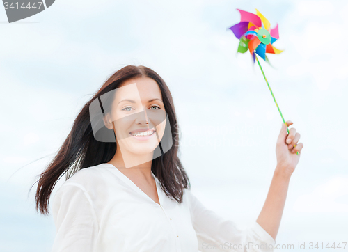 Image of girl with windmill toy on the beach