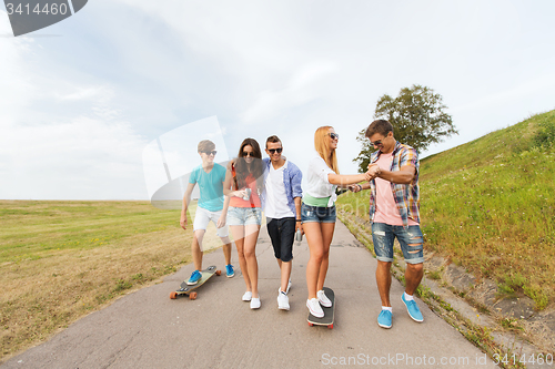 Image of happy teenage friends with longboards outdoors