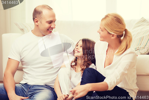 Image of parents and little girl sitting on floor at home