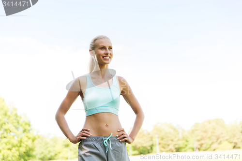 Image of happy young woman exercising outside