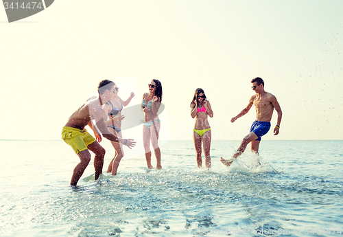 Image of happy friends having fun on summer beach