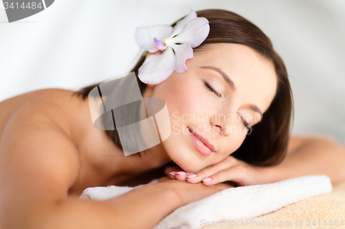 Image of beautiful woman with flower in her hair in spa