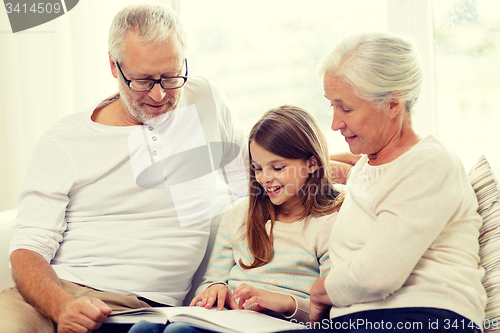 Image of smiling family with book at home