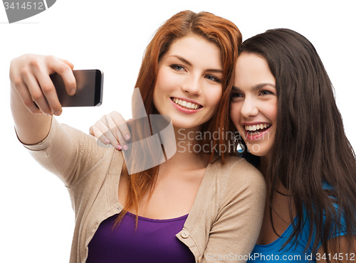 Image of two smiling teenagers with smartphone