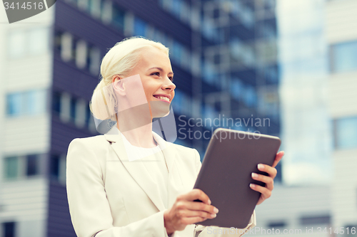 Image of smiling businesswoman with tablet pc outdoors