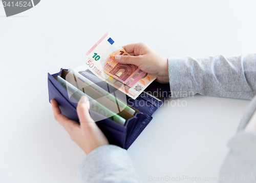 Image of close up of woman hands with wallet and euro money