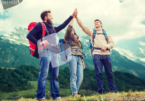 Image of group of smiling friends with backpacks hiking