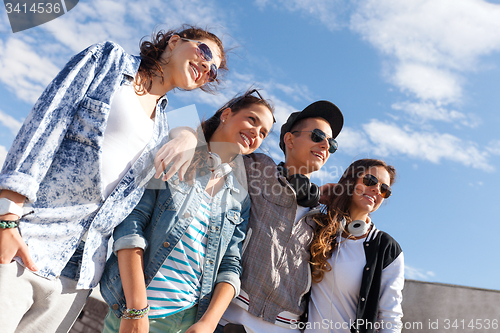 Image of smiling teenagers in sunglasses hanging outside