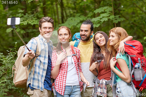 Image of friends with backpack taking selfie by smartphone