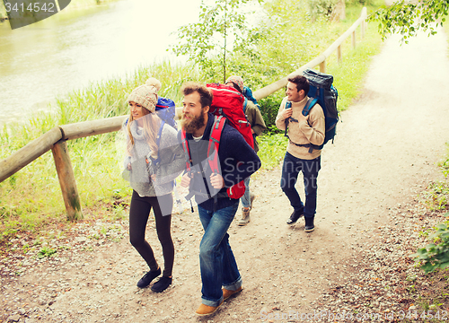 Image of group of smiling friends with backpacks hiking