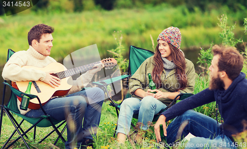 Image of group of tourists playing guitar in camping