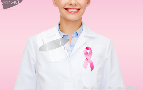 Image of smiling female doctor with cancer awareness ribbon