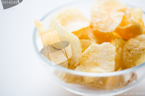 Image of close up of crunchy potato crisps in glass bowl