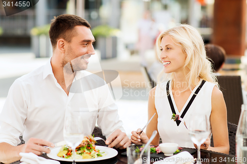 Image of happy couple eating dinner at restaurant terrace