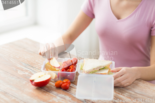 Image of close up of woman with food in plastic container