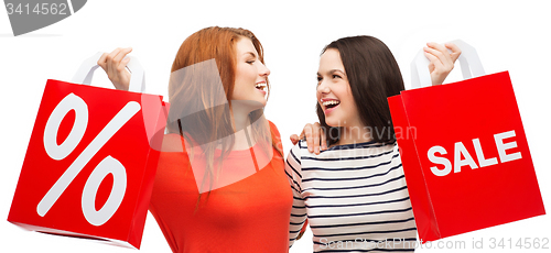 Image of two smiling teenage girl with shopping bags