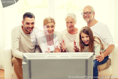 Image of happy family watching tv at home