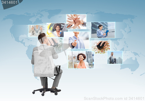 Image of businessman sitting in office chair from back