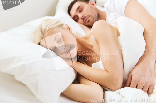 Image of happy couple sleeping in bed at home