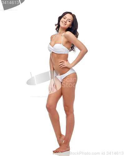 Image of happy young woman in white bikini swimsuit